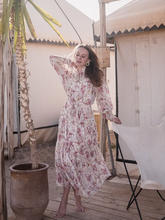 a lady wears a pink iris printed lantern sleeve maxi dress